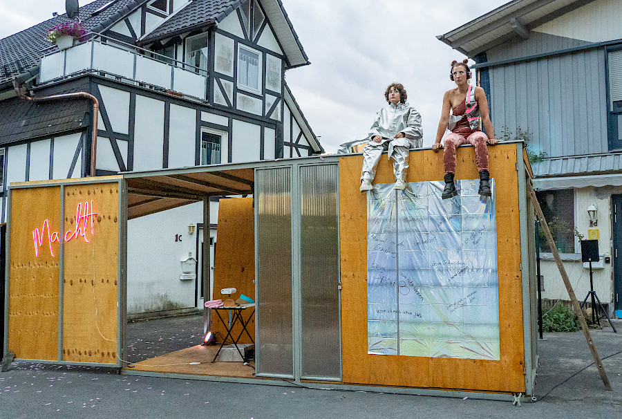 Szenenfoto aus SUPER BADASS WOMEN, beide Schauspielerinnen sitzen auf dem Dach des Containers.