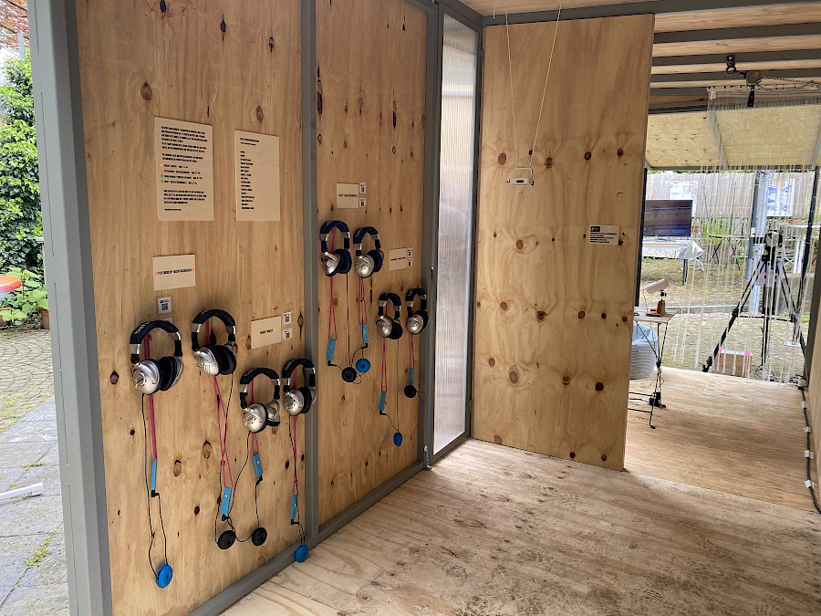 Im neuen, kleinen Container; mehrere Kopfhörer hängen bereit