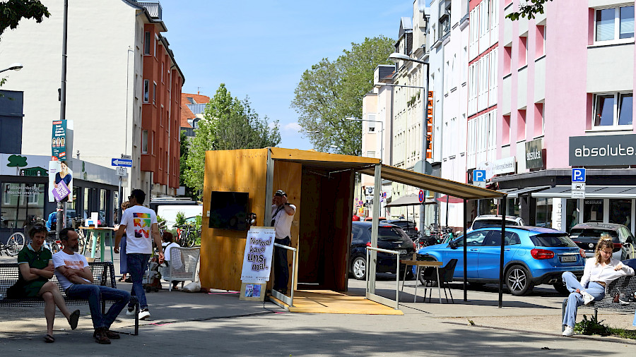 Der neue, kleine Container von Weitem. Er steht geöffnet und eingerichtet auf einem Platz